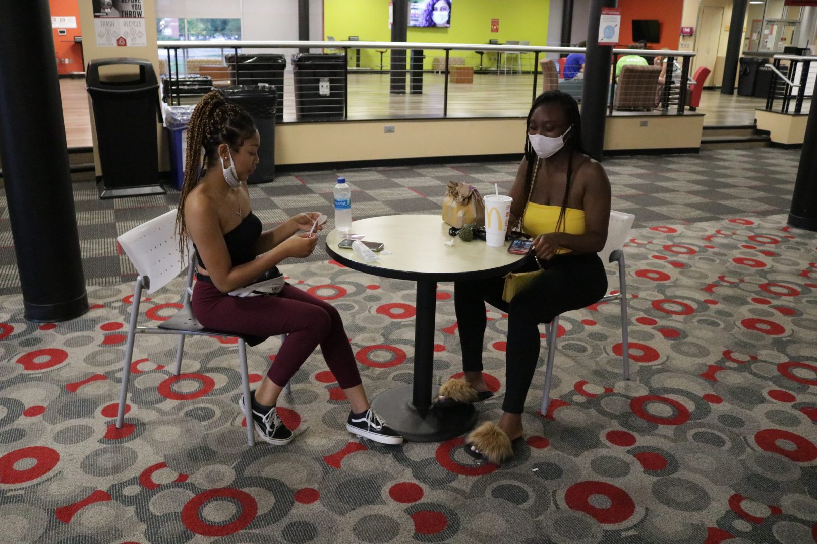 Sophomore psychology major Desiree Legree and sophomore exercise science major Gerri Bonner eat inside in Schwitzer Student Center while wearing masks on Sept. 13.