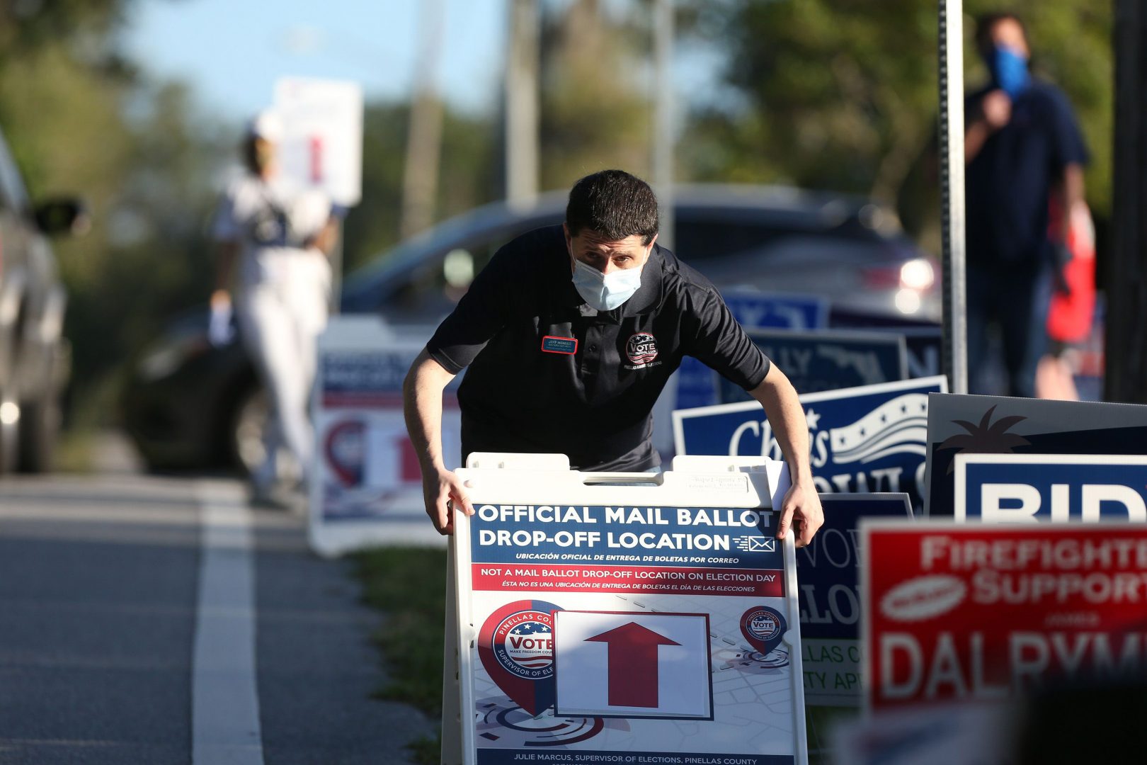 Jeff Mendes, an elections deputy with the Pinellas County Supervisor of Elections, displays a sign to inform voters of a mail ballot drop-off location at The Centre of Palm Harbor.