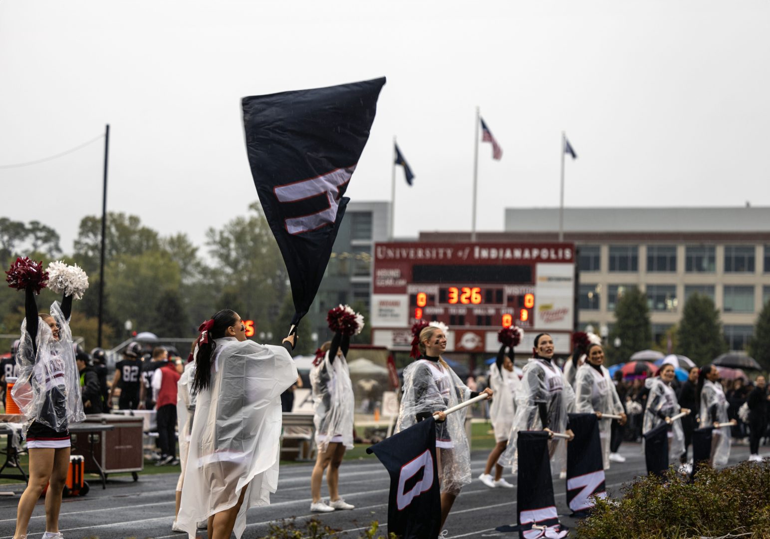 UIndy cheerleaders wave flags