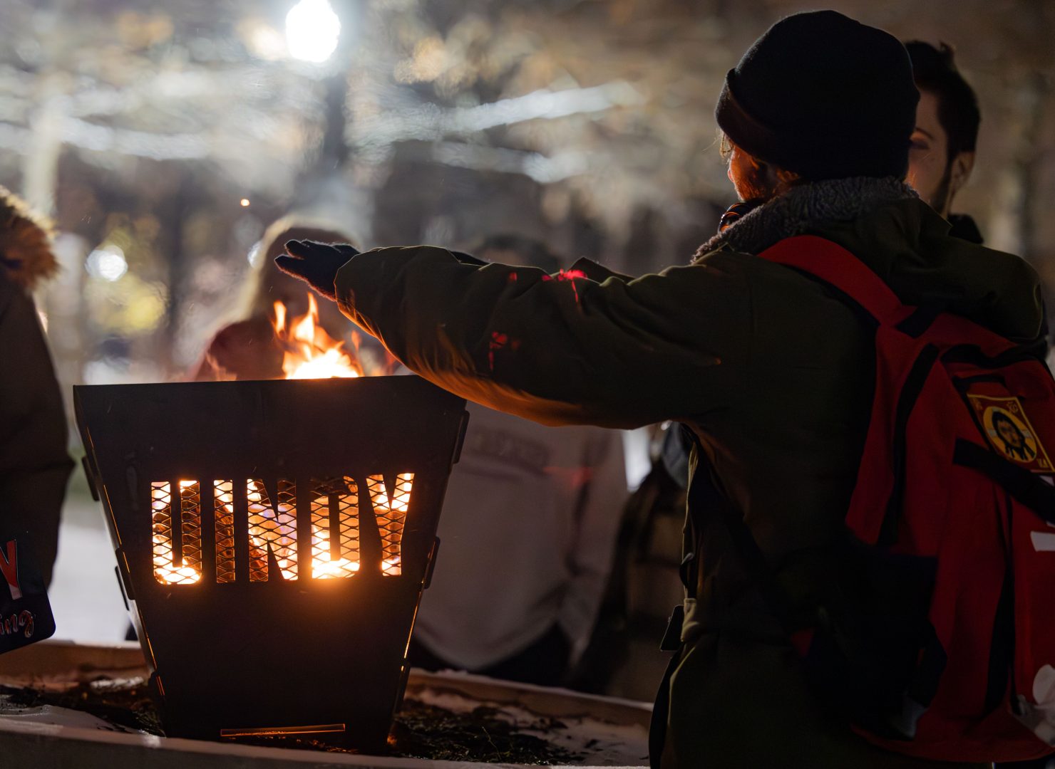 Students place hands over UIndy branded fire holder