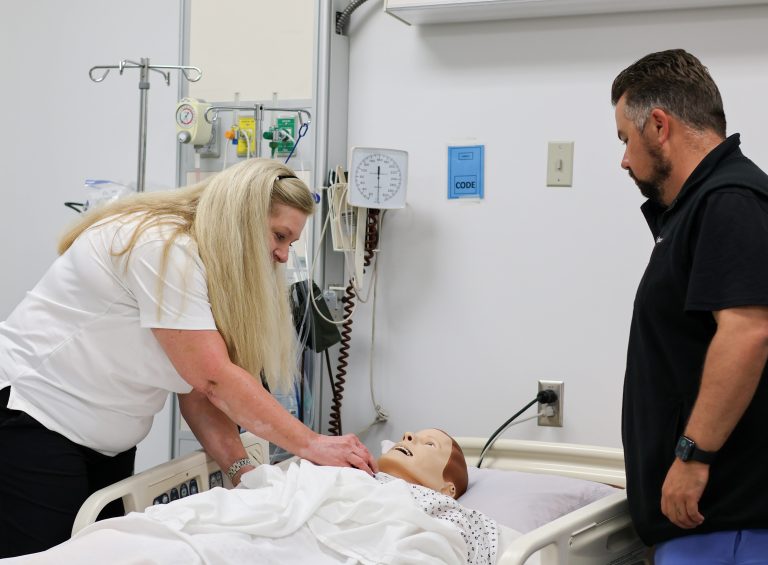 Two people working on a medical doll