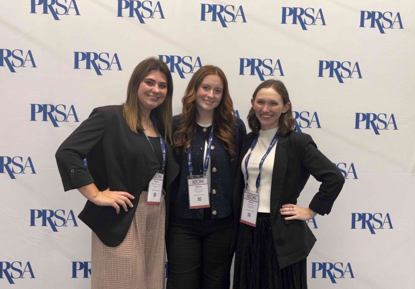 Three girls stand together at the PRSA conference.